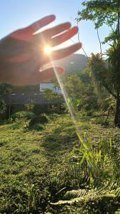 una persona rociando el césped en un campo en Acampamento no Camping Natureza Divina, en Paraty