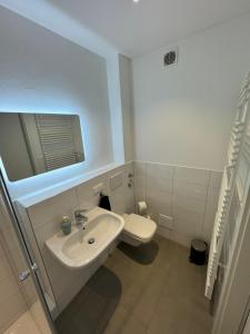 a white bathroom with a sink and a toilet at Moderne 2,5-Zimmer Wohnung in Toplage in Hannover