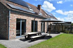 a patio with a picnic table and an umbrella at de Graspieper in Oostduinkerke