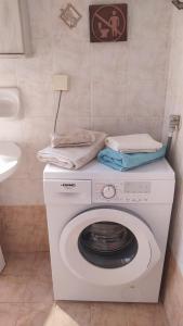 a washing machine with towels on top of it in a bathroom at Vasiliki's apartment in Sparta
