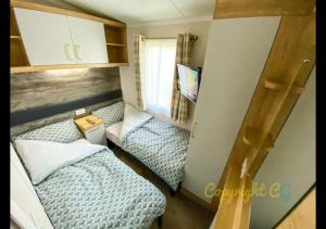 a small room with two beds and a desk at MP413 - Camber Sands Holiday Park - Close to Facilities - Free Wifi - Sleeps 8 - Large Decking in Camber