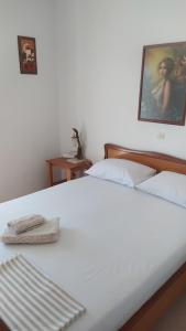 a white bed with two towels on top of it at Vasiliki's apartment in Sparti