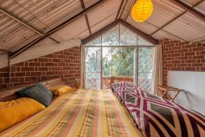a room with a row of beds in a brick wall at Unique 2BHK in Bhowali Red Brick Quarter in Bhowāli