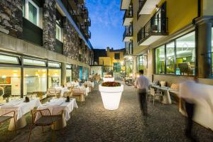 a man walking through a restaurant with tables at Castanheiro Boutique Hotel in Funchal