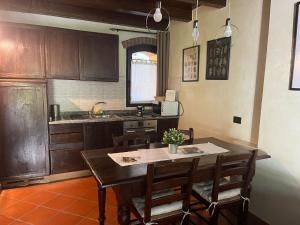 een keuken met een tafel en stoelen en een keuken met een wastafel bij Bilocale Dafne Abbadesse Guest House in Milaan