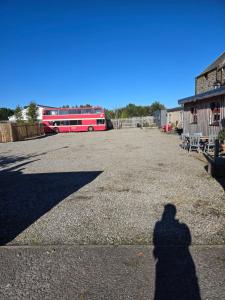 a shadow of a person standing in front of a bus at Archie The Double Decker Bus in Tain
