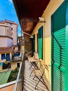 a balcony with chairs and green doors on a building at Oh!megna in Omegna