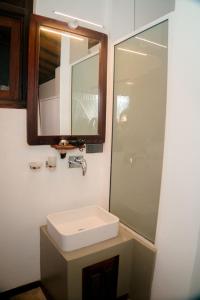 un baño con lavabo y espejo en Lucky Tuna, en Unawatuna