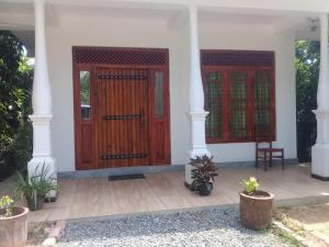 韦利格默Dilana Villa的一座房子,设有两扇木门和门廊 更多2张照片