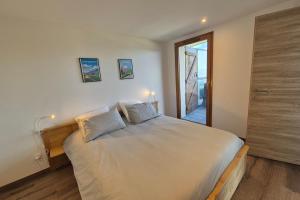 a bedroom with a large white bed with two pillows at Superbe appartement neuf idéal pour des vacances en famille in La Féclaz