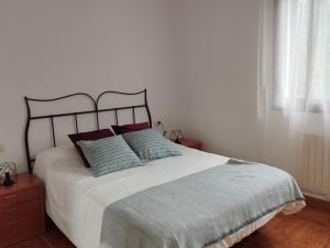 a bedroom with a large white bed with red pillows at A casiña de Tuli in Vigo