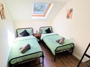 two twin beds in a room with a window at Luxury Spacious Apartment- Sleeps 4 Loughborough in Loughborough