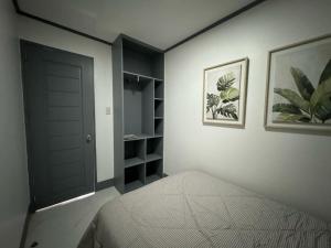 a bedroom with a bed and a black door at MDEC Apartments in Hilongos +3 photos