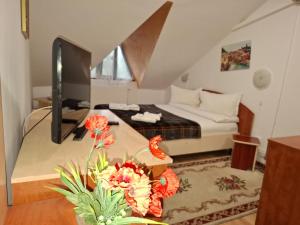 a bedroom with a bed and a table with flowers at Casa Boiereasca in Iaşi