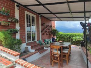 a patio with a table and chairs under awning at Oasis Natural in Santa Fe de Antioquia