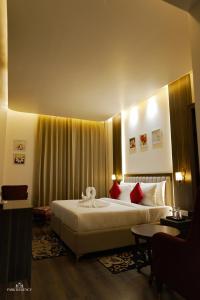 a hotel room with a large bed with red pillows at Park Regency Kapurthala in Kapūrthala