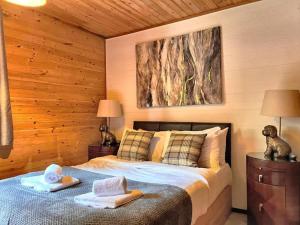 a bedroom with a bed with two towels on it at Goldcrest 3-Hot Tub-Woodland Lodges-Carmarthenshire-Tenby in Carmarthen