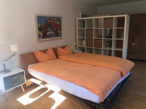 a bedroom with a large bed with an orange blanket at Glück in Benrath in Düsseldorf +33 photos