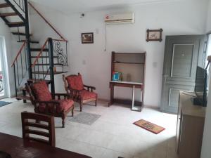a living room with chairs and a table and stairs at Don Jose in Piquete
