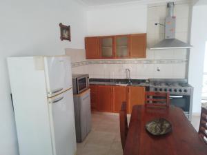a kitchen with a wooden table and a white refrigerator at Don Jose in Piquete