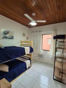 a bedroom with a bed and a ceiling fan at Cobertura 3 quartos c Piscina Privativa e Churrasqueira in Guarujá