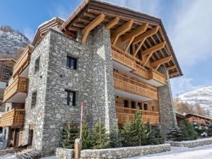 a large stone building with a wooden roof at Appartement 95m², Sud-Est, Jacuzzi, Val d'Isère, 4 Suites, Parking, Animaux OK - FR-1-567-73 in Val dʼIsère