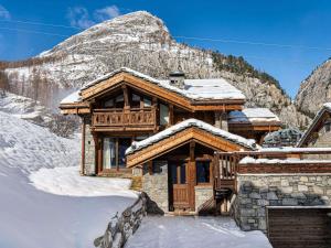 ein Blockhaus im Schnee mit einem Berg in der Unterkunft Chalet spacieux près des pistes avec sauna et WiFi, animaux admis - FR-1-567-69 in Val dʼIsère