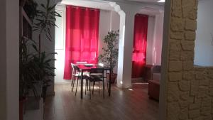 Un comedor con cortinas rojas y una mesa y sillas. en Piso centro Gandia, en Gandía 14 fotos más