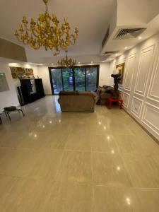 ein Wohnzimmer mit einer Couch und einem Kronleuchter in der Unterkunft Elegant Villa in Hyde Park in New cairo
