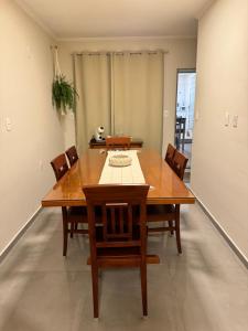 a dining room with a wooden table and chairs at Casa no centro in Serra Negra