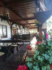 ein Restaurant mit Tischen und Bänken und Blumen in einem Raum in der Unterkunft Casa Boiereasca in Iaşi + 59 Fotos