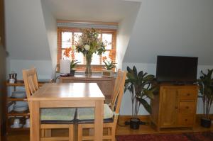 ein Esszimmer mit einem Tisch und einem Fernseher in der Unterkunft Pinecroft Barn - Relax & Unwind! in Storrington