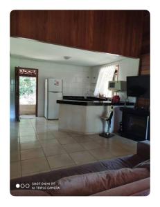 a kitchen with a white refrigerator and a tile floor at Sitio para relaxar in Carmo do Cajuru +1 photo