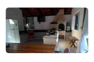 a kitchen with a stove and a refrigerator at Sitio para relaxar in Carmo do Cajuru
