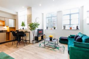 a living room with a green couch and a table at The Lanes Royale - Rose Platinum Properties in Brighton & Hove +22 photos