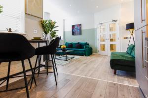 a living room with a green couch and a table at The Lanes Royale - Rose Platinum Properties in Brighton & Hove