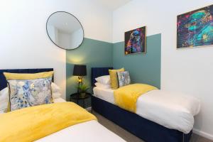 a bedroom with two beds and a mirror at The Lanes Royale - Rose Platinum Properties in Brighton & Hove