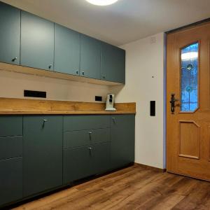 an empty kitchen with green cabinets and a door at Ferienwohnung Kretschmar in Oberammergau