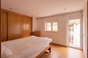 a bedroom with a bed and a window at Casa Amarela - Serra da Estrela Portugal in Verdelhos