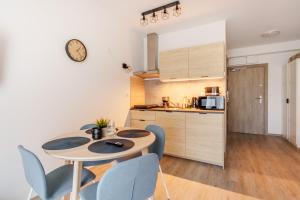 a kitchen with a table and chairs in a room at Apartament Moderno z dostępem do HolidayPark&Resort in Sianozety