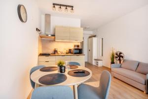 a kitchen and living room with a table and chairs at Apartament Moderno z dostępem do HolidayPark&Resort in Sianozety +20 photos