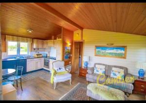 a living room with a couch and a kitchen at Tore Petty - spa bath and sauna - Romney Marsh, Kent in Brookland