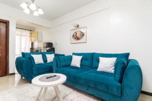 a living room with a blue couch and a table at 1 Bed and exta bedroom at Kilimani Yaya centre-Nairobi in Nairobi