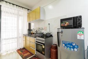 a kitchen with a microwave on top of a refrigerator at 1 Bed and exta bedroom at Kilimani Yaya centre-Nairobi in Nairobi