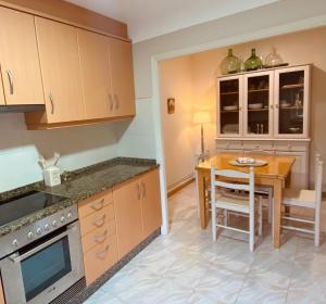 a kitchen with a table and a dining room at Alojamiento Virita in Nigrán