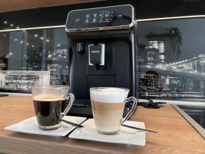 two cups of coffee sitting on a table next to a coffee machine at Apartman La Luna in Daruvar