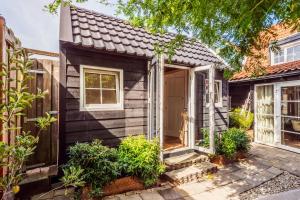 a small black house with a front door at Tiny house Zaandam in Zaandam