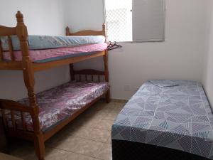 a bedroom with two bunk beds and a bed at Apto Domeni, seu conforto a 10 min da praia! in Praia Grande