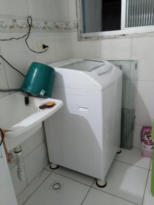 a toilet in a bathroom next to a sink at Apto Domeni, seu conforto a 10 min da praia! in Praia Grande