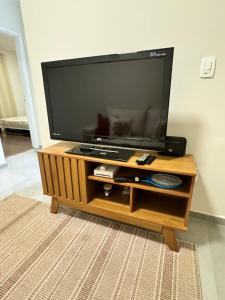 a large flat screen tv on a wooden entertainment center at Casa no centro in Serra Negra